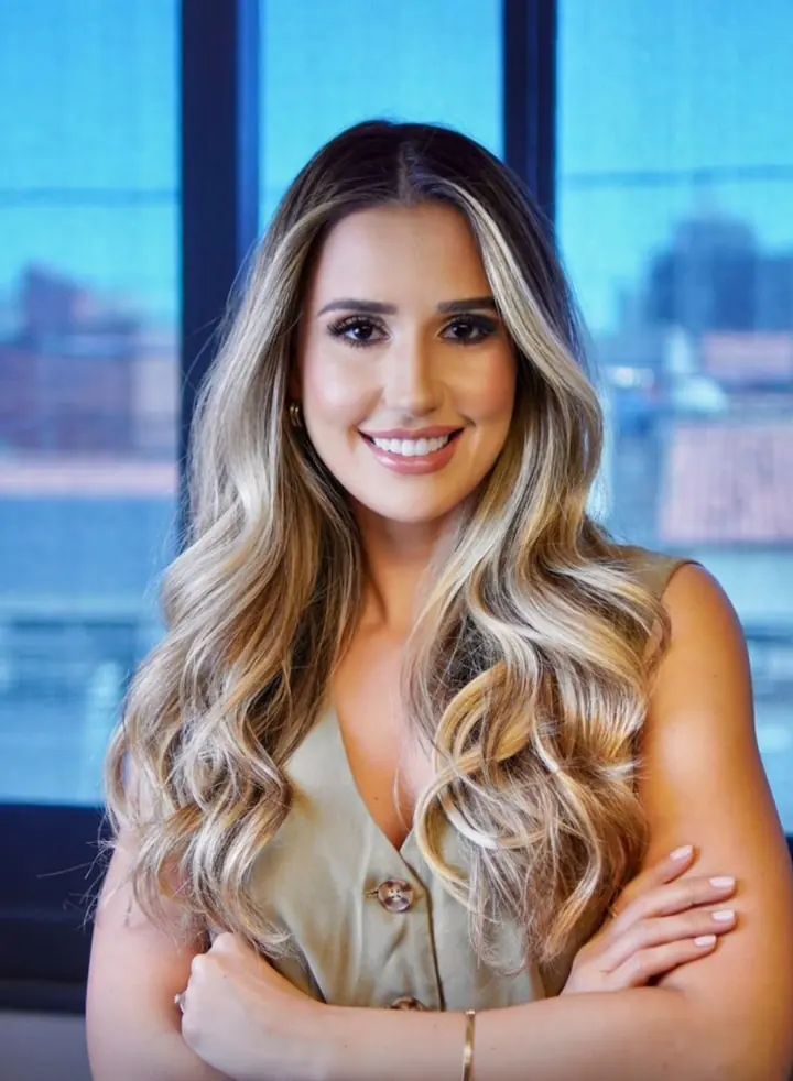 Dra. Fernanda Araújo, cardiologista e professora universitária, de braços cruzados, sorrindo